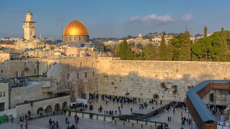 Vy �ver Tempelberget och Klagomuren, klippdomens guldkupol lyser i kv�lsssolen medan den �ppna plasten nedanf�r ligger i skugga.